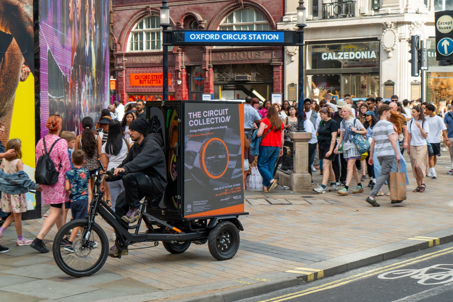 AdBike passing Oxford Circus station through dense crowds